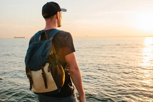 Deniz kenarı bir sırt çantası ile bir turist. Seyahat, turizm, rekreasyon.