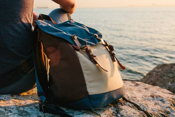 A tourist with a backpack on the coast. On the Sunset. Travel, tourism, recreation. Travel concept.