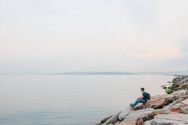 Deniz kenarı bir sırt çantası ile bir turist. Seyahat, turizm, rekreasyon.
