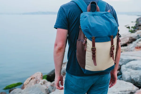 Deniz kenarı bir sırt çantası ile bir turist. Seyahat, turizm, rekreasyon.