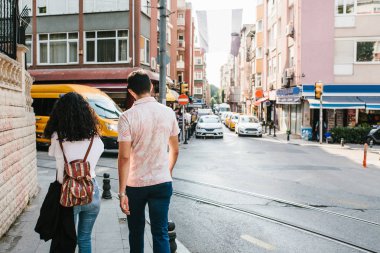 Istanbul'da cadde boyunca yürüyen genç bir çift. Kentsel yaşam tarzı. Rutin, şehir merkezinde. Türkiye'de yaşam.