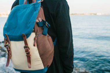 Deniz kenarı bir sırt çantası ile bir turist. Seyahat, turizm, rekreasyon.