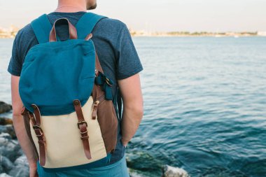 Deniz kenarı bir sırt çantası ile bir turist. Seyahat, turizm, rekreasyon.