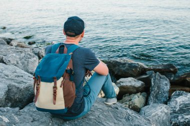 Deniz kenarı bir sırt çantası ile bir turist. Seyahat, turizm, rekreasyon.