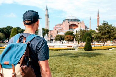 Bir seyahat adam yakınındaki ünlü Aya Sofya cami Türkiye'de Istanbul'da Sultanahmet Meydanı'nda bir sırt çantası ile. Seyahat, turizm, gezi.