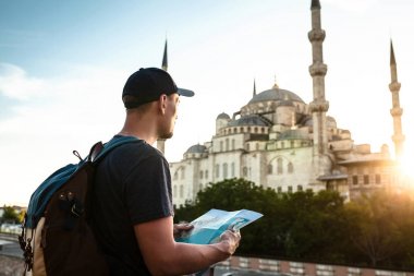 Bir sırt çantası ile bir beyzbol şapkalı bir seyahat planın Sultanahmet Camii - Istanbul 'un ünlü görüş yanında bakıyor. Seyahat, turizm, gezi.
