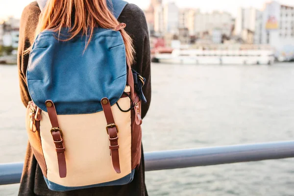 Istanbul 'un arka planda bir sırt çantası-günbatımında Boğaz'ın yanındaki genç güzel turist kızla. Türkiye. Dinlenme, tatil, hiking.