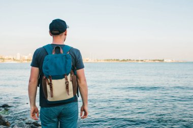 Deniz kenarı bir sırt çantası ile bir turist. Seyahat, turizm, rekreasyon.
