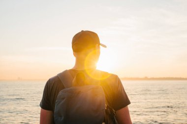 Deniz kenarı bir sırt çantası ile bir turist. Seyahat, turizm, rekreasyon. Sunset bulvarında.