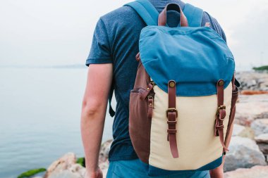 Deniz kenarı bir sırt çantası ile bir turist. Seyahat, turizm, rekreasyon.