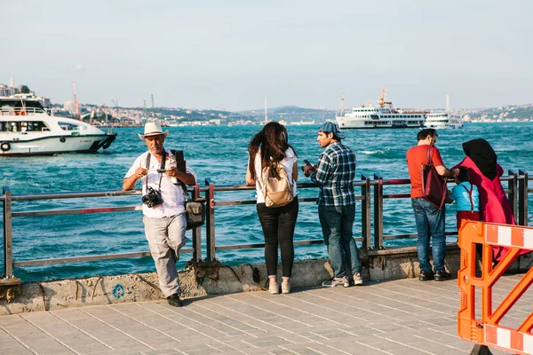 Istanbul, 15 Haziran 2017: Yaşlı fotoğrafçı ve iskeleye iki genç insan. Türkiye. Boğaz'ın arka planda olduğunu.