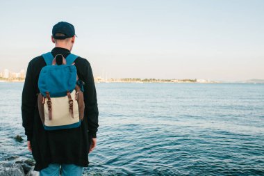 Deniz kenarı bir sırt çantası ile bir turist. Seyahat, turizm, rekreasyon.