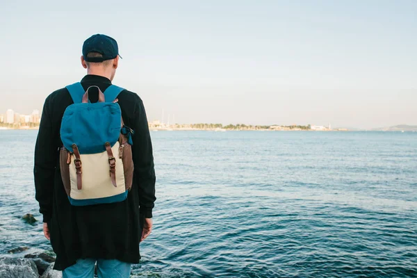 Deniz kenarı bir sırt çantası ile bir turist. Seyahat, turizm, rekreasyon.