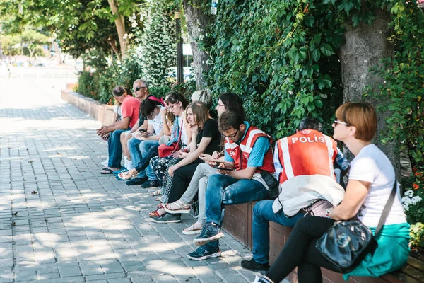 Istanbul, 16 juin 2017 : deux policiers turistes sur la place Sultanahmet, avec un groupe de personnes assises à proximité . — Photo