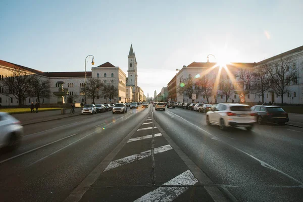 Yolun bir bakış, Münih - Almanya Bavyera'da başkenti sokak Leopoldstrasse üzerinde. Hızlı hareket araba günbatımı arka plan üzerinde bulanık.