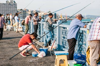 Istanbul, 15 Haziran 2017: Galata Köprüsü ve balık üzerinde yerel halkın standından birçok balıkçı. Istanbul sakinlerinin geleneksel hobi.