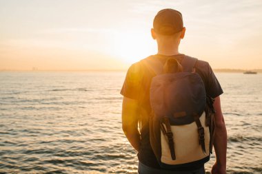 Deniz kenarı bir sırt çantası ile bir turist. Seyahat, turizm, rekreasyon. Sunset bulvarında.