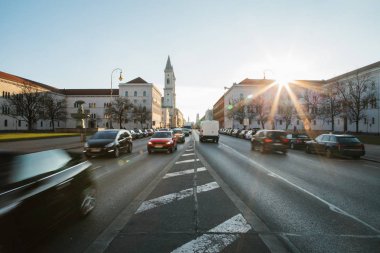 Yolun bir bakış, Münih - Almanya Bavyera'da başkenti sokak Leopoldstrasse üzerinde. Hızlı hareket araba günbatımı arka plan üzerinde bulanık.