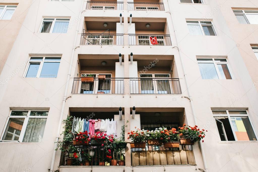 Residential building in Istanbul with balconies decorated with flowers and small Turkish flags. Turkey. Ordinary peoples life. Authentic.