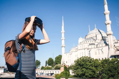 Sanal gerçeklik gözlüklü bir gezgin. Dünyanın dört bir yanından sanal seyahat kavramı. Arka planda Türkiye'de Istanbul'da Sultanahmet Camii. Geleceğin teknolojisi kavramı.
