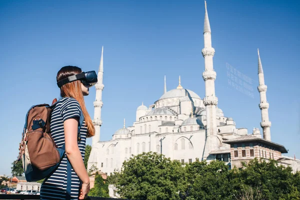 Sanal gerçeklik gözlüklü bir gezgin. Dünyanın dört bir yanından sanal seyahat kavramı. Arka planda Türkiye'de Istanbul'da Sultanahmet Camii. Geleceğin teknolojisi kavramı.