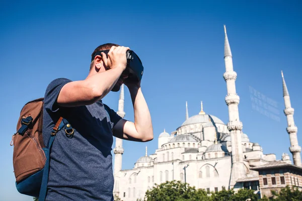 Un viajero con gafas de realidad virtual. El concepto de viaje virtual alrededor del mundo. En el fondo la mezquita azul Sultanahmet en Estambul en Turquía. Concepto de tecnología futura . — Foto de Stock