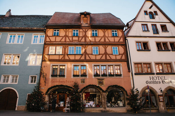 Rothenburg ob der Tauber, Germany, December 30, 2016: A street with shops and hotels during the Christmas holidays. Beautiful decorated houses in traditional style. Europe.