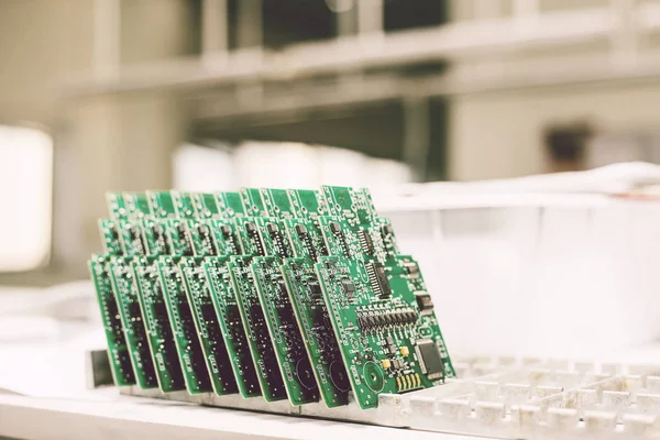 Üst üste yedek parça imalatı için fabrikada bilgisayar panoları standı.