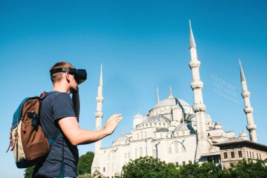 Sanal gerçeklik gözlüklü bir gezgin. Dünyanın dört bir yanından sanal seyahat kavramı. Arka planda Türkiye'de Istanbul'da Sultanahmet Camii. Geleceğin teknolojisi kavramı.