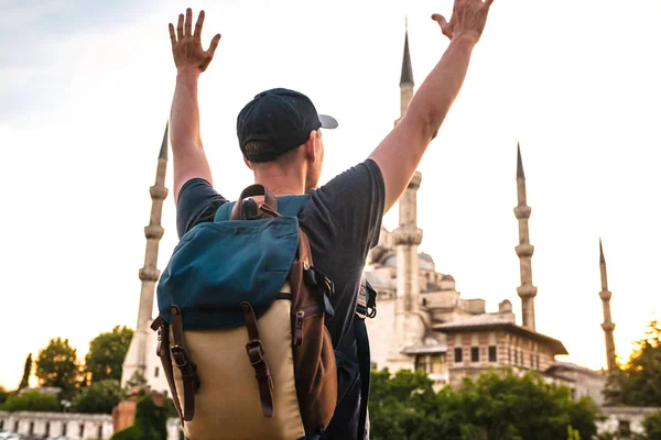 Turist genç adam Istanbul'da dünyaca ünlü Sultanahmet Camii yanında gösterilen ellerini kaldırdı ne kadar mutlu ve özgür o. Yolculuk.