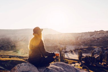 Pratik Yoga bir dağın tepesinde güneş doğarken genç güzel kız. Gevşeme uygulamaları.