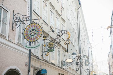 Avusturya, Salzburg, 1 Ocak 2017: Getreidegasse Caddesi üzerinde dükkan belirtileri reklam. Eski şehrin pitoresk bir sokakta. Salzburg Ticaret Merkezi. Avrupa'nın Noel tatili.