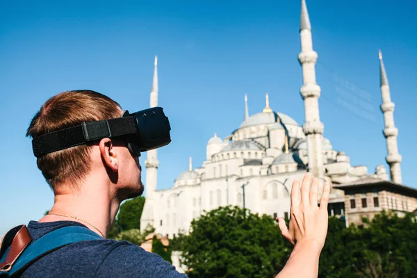 Sanal gerçeklik gözlüklü bir gezgin. Dünyanın dört bir yanından sanal seyahat kavramı. Arka planda Türkiye'de Istanbul'da Sultanahmet Camii. Geleceğin teknolojisi kavramı.