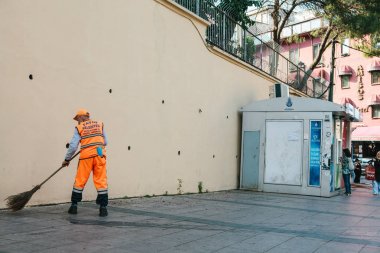 Istanbul, 15 Haziran 2017: kapıcı parlak turuncu üniformalı Sultanahmet semtinde sokakta döşemeyi süpürme