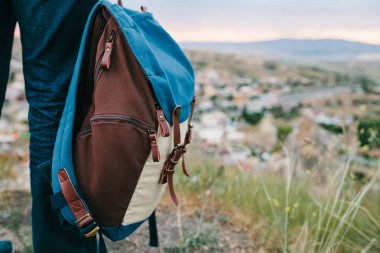 Bir turist bir yükseklikten günbatımında bir dağ town üzerinde görünüyor. Turizm, hiking kavramı. Backpacker