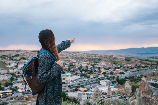 El günbatımında şehrin üzerinde gösterilen genç kadın turist ile yüksek noktası. Turizm, dinlenme, tatil.