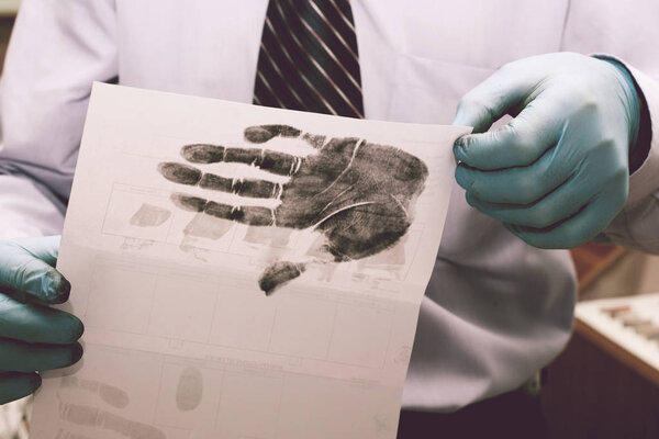 The investigator takes fingerprints from the suspect in the crime. Investigation is a crime. Crime.
