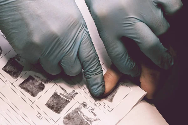 Ο ερευνητής παίρνει δακτυλικά αποτυπώματα από ο ύποπτος για το έγκλημα. Έρευνα είναι ένα έγκλημα. Έγκλημα. — Φωτογραφία Αρχείου