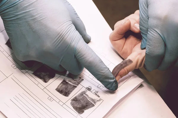 The investigator takes fingerprints from the suspect in the crime. Investigation is a crime. Crime. — Stock Photo, Image