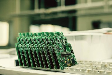 Üst üste yedek parça imalatı için fabrikada bilgisayar panoları standı.