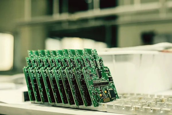 Üst üste yedek parça imalatı için fabrikada bilgisayar panoları standı.