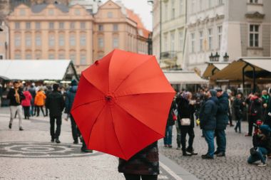 Prag eski şehir Meydanı üzerinde geleneksel kırmızı şemsiye ile bir rehber turist turistik yerleri ziyaret etmek için davet ediyor. Noel Turizm. Çek Cumhuriyeti. Europe.