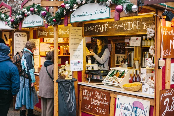 Prag, 15 Aralık 2016: Satıcı müşteriler bal ve çeşitli şarapların geniş bir seçki sunuyor. Noel Dükkanı. Noel alışveriş. Avrupa'nın Noel Kutlamaları.