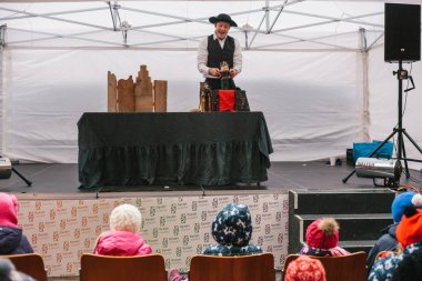 Prag, 18 Aralık 2016: Tasarım Pazar Prag - takım elbise ve şapka gösterir kukla tiyatrosu önünde iskemlede oturan çocuk sokak Sahne Alanı'nda erkeklerde