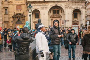 Prag, 24 Aralık 2016: Kalabalık manzaraları izlerken, söz ve fotoğraf çekmek turist Prag sokakta