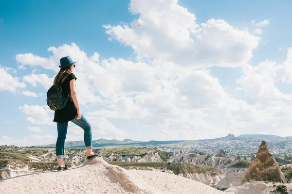 Jonge mooie reizen meisje met een rugzak op de top van een heuvel in Cappadocië, Turkije. Reizen, vrijheid, succes en prestatie. — Stockfoto