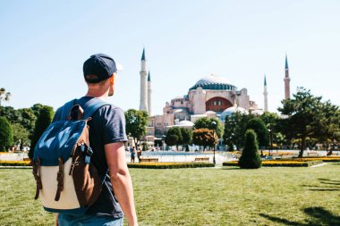Bir seyahat adam yakınındaki ünlü Aya Sofya cami Türkiye'de Istanbul'da Sultanahmet Meydanı'nda bir sırt çantası ile. Seyahat, turizm, gezi.