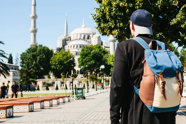 Sultanahmet Camii yanındaki bir sırt çantası ile bir beyzbol şapkalı bir adam Istanbul'da ünlü bir görüntüdür. Seyahat, turizm, gezi.