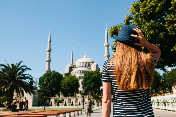 Nuori tyttö matkusti hattu päässä takana Sultanahmet Square vieressä kuuluisa moskeija nimeltään sininen moskeija Istanbulissa, Turkki. Matkailu, matkailu, nähtävyydet . — kuvapankkivalokuva