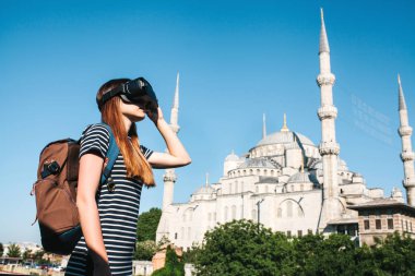 Sanal gerçeklik gözlüklü bir gezgin. Dünyanın dört bir yanından sanal seyahat kavramı. Arka planda Türkiye'de Istanbul'da Sultanahmet Camii. Geleceğin teknolojisi kavramı.